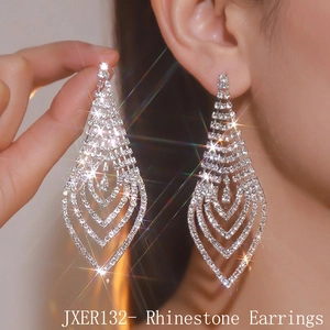 Detailed view of layered V-shaped long tassel rhinestone earrings on a model's ear