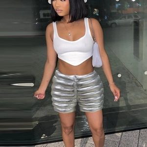 Close-up of stylish metallic silver puffer shorts and a white crop top on model