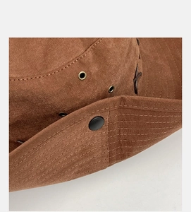 Close-up of brown outdoor sun hat with bronze ventilation holes and reinforced stitching
