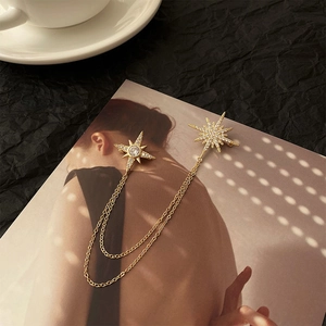 Elegant gold hexagram star chain brooch with white zircons on a fashion magazine