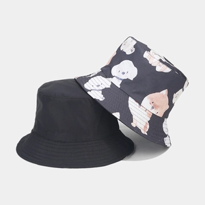 Detail of reversible bucket hat showing cute cartoon dog print and plain black fabric texture