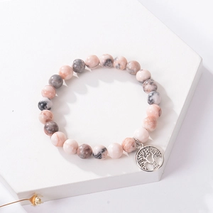 Detail of beaded bracelet with natural stone texture and tree of life metal pendant