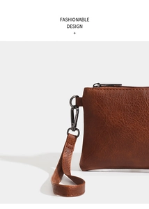 Close-up of brown litchi pattern PU leather clutch with metal zipper and wrist strap hook