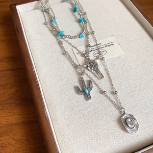 Detail of silver multi-layer necklace with turquoise beads and western charms