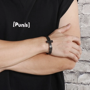 Close-up of adjustable black mesh strap bracelet with a metallic cross for men
