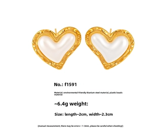 Detail of gold-plated heart stud earrings with white bead inlay and steel frame