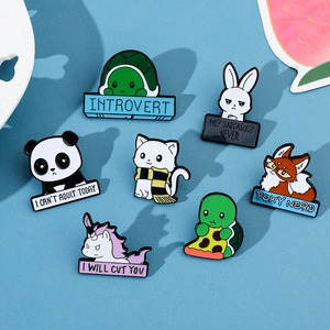 Flat lay of colorful enamel animal lapel pins with funny quotes on a blue background