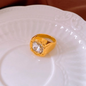 Close-up of polished gold-plated ring with a large round cubic zirconia in bezel setting