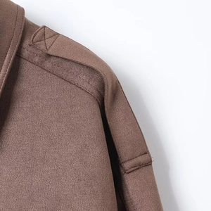 Close-up of dark brown suede jacket featuring epaulette shoulder strap and neat stitching