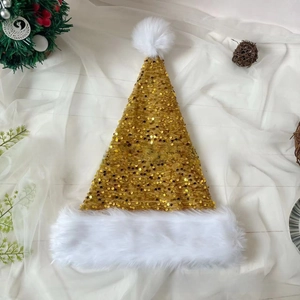 Macro shot of gold sequin Christmas hat with soft white faux fur trim on white fabric