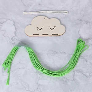 Detail of wooden cloud hair clip holder with engraved eyelashes and green cotton rope