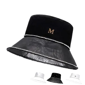 Elegante cappello a secchiello in velluto nero con tesa in rete e dettaglio lettera M