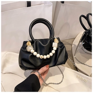 Detail of black pleated cloud bag with marble beads and silver chain on white suit