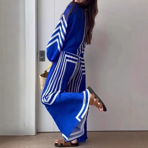 Detailed view of blue and white geometric striped pleated fabric on wide-leg trousers