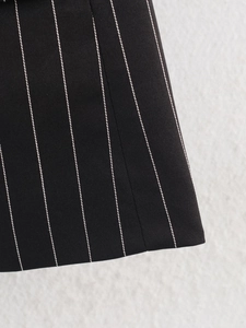 Detailed macro view showing the high-quality striped suit fabric texture and precise stitching