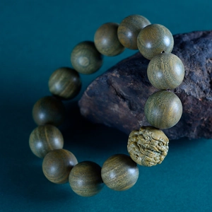 Green Sandalwood Pixiu Buddhist beads bracelet with detailed carving on dark rock base