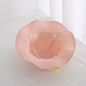 Detailed interior view of pink woven children's straw hat with white elastic chin strap