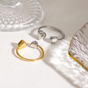 Bagues ouvertes cœur bicolores en acier inoxydable or et argent sur fond clair