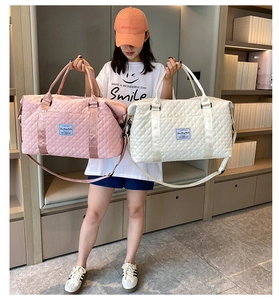 Quilted nylon travel bags in pink and white shown with model for size comparison