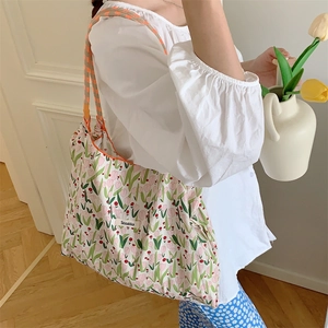 Floral canvas tote bag with tulip print shown being worn by a model in a natural setting