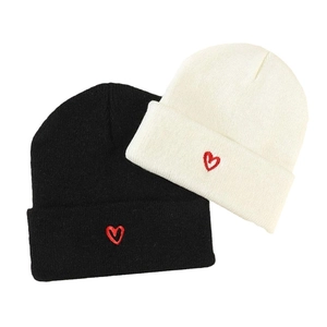 Set of two knit beanies in black and beige with red heart embroidery for winter warmth