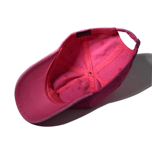 Detailed interior of a rose red cotton baseball cap with wash label and stitching