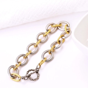 Two-tone gold and silver link chain bracelet with OT toggle clasp on white background