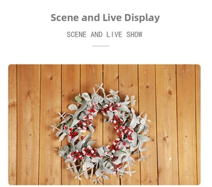 Close-up of a Christmas wreath with red berries and flocked eucalyptus on wood wall