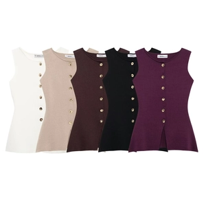 Detail of five colors of knit vests with golden buttons and vertical side slits