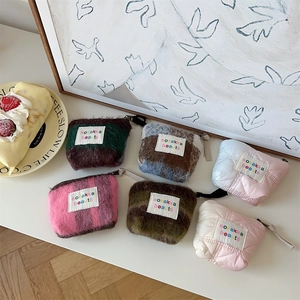 Macro view of plush and quilted mini pouches with zip closures and embroidered patches