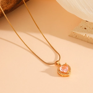 Nahaufnahme des Herzanhängers mit rosa Edelstein und kleinen Diamanten auf Goldkette