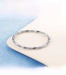 Polished silver beaded bracelet with bamboo joint design on blue glitter background