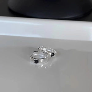 925 silver needle black heart hoop earrings with polished finish on reflective white surface