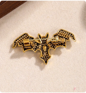 Detail view of the vintage gold bat brooch showing the secure safety pin clasp on the back