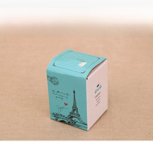 Detail view of a vintage Paris-themed gift box with Eiffel Tower print and blue-green lid