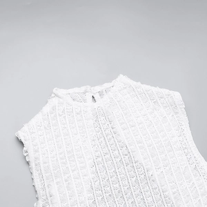 Detailed macro view of white textured fabric with fringe details on a sleeveless dress