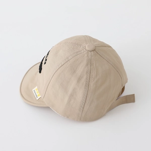 Détail macro de la casquette bébé beige en tissu respirant avec bord souple