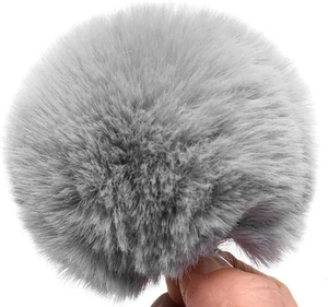 Detail of soft grey faux fur pom-pom accessory featuring fluffy plush texture for costumes