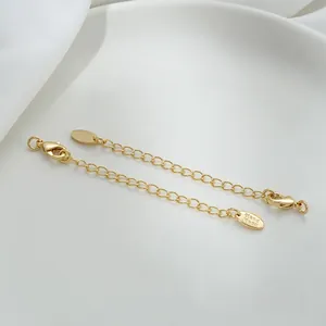 Detail of 14K gold plated jewelry extender chains with lobster clasp and handmade tags