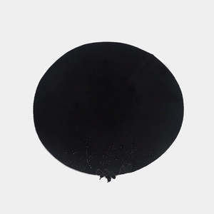 Dettaglio di basco nero in lana con elegante ricamo floreale e decorazione di perline fini