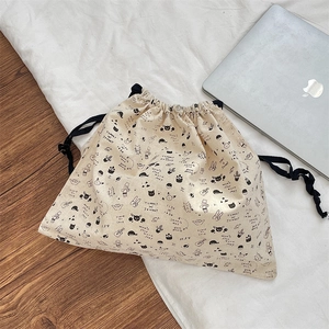 Detailed view of beige cotton drawstring pouch featuring cute cat graffiti prints