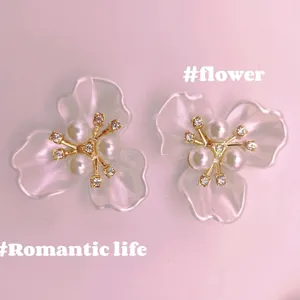 Elegant floral stud earrings with iridescent petals and pearls on golden base