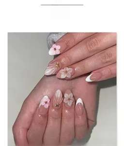 Detail of French almond press-on nails with 3D pink flowers and pearl accents