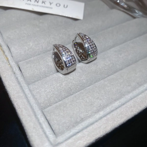 Detailed macro of silver U-shaped hoop earrings with micro-pave cubic zirconia inlay