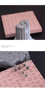 Detailed macro view of retro punk star earrings with inlaid multicolor zircon crystals