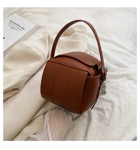 Detailed macro view of dark brown woven leather texture on this stylish box bucket handbag