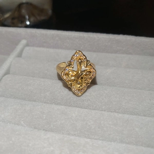 Macro detail of gold vintage flower ring with white zircon stones on a gray velvet tray