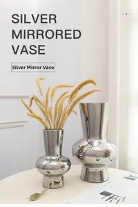 Detail view of two silver mirrored ceramic vases with reflective electroplated finish