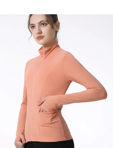 Détail d'une veste de yoga rose ajustée montrant les passe-pouces et le col montant