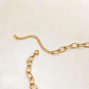 Detailed close-up of 18K gold lobster clasp and adjustable extender chain on the necklace